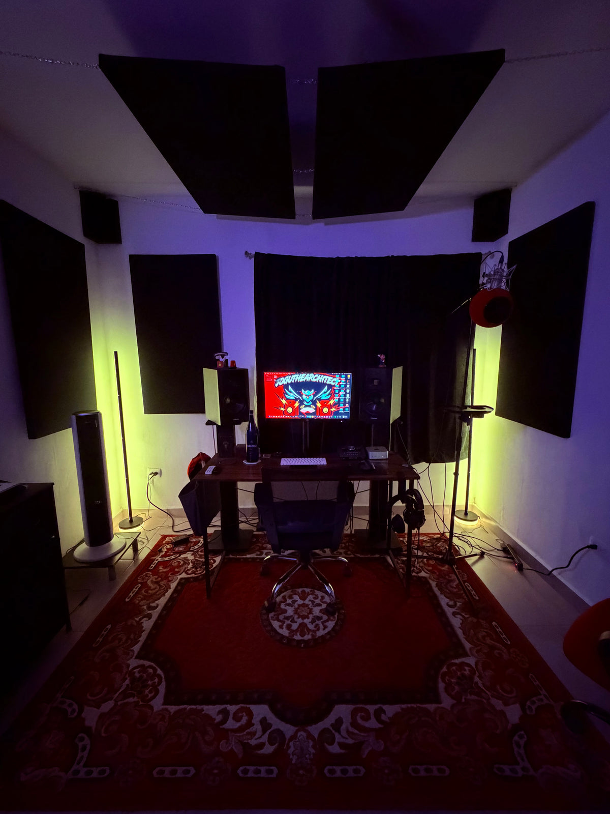 The JTA studio: mixing desk between two monitors and red floor lamps